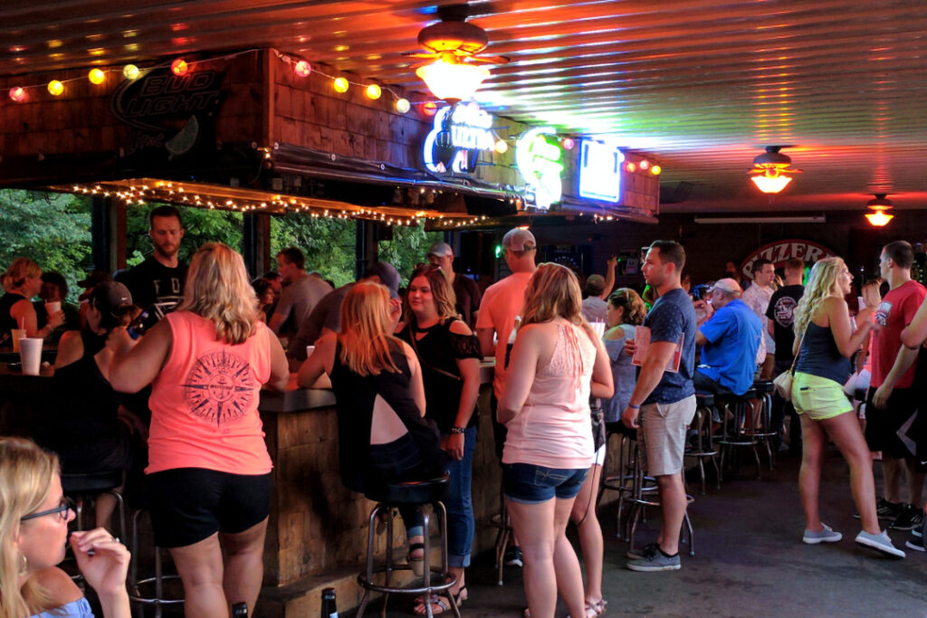 A graphic of a crowd of guests standing near the bar in the Back Bar