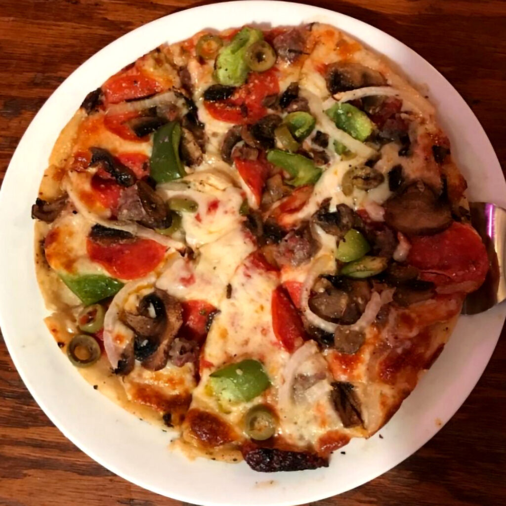 A graphic of a skinny crust deluxe pizza on a plate.